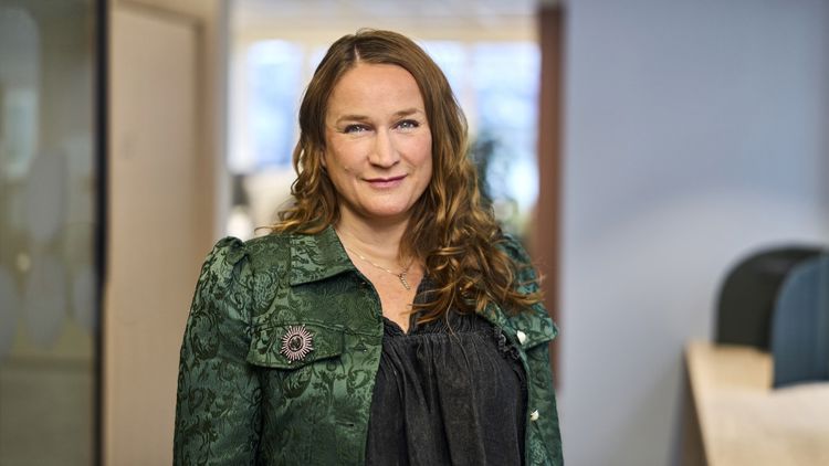 Bildet viser Ingvill Kvernmo som står i et kontorlandskap