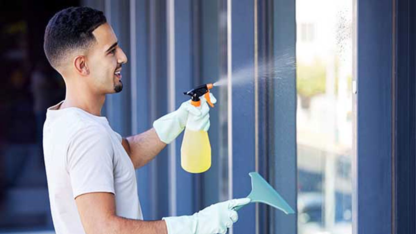 Mann som rengjør et vindu. Foto: Colourbox