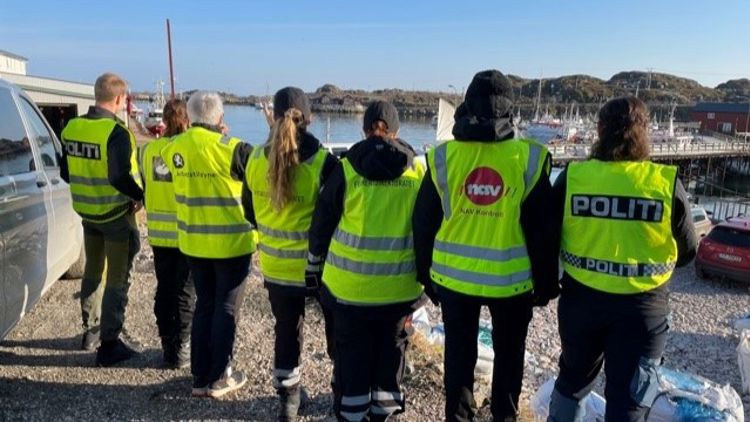Bildet viser sju personer med gul vest som står med ryggen til. På vestene er det logoer til Politiet, Skatteetaten, Arbeidstilsynet, NAV og Fiskeridirektoratet. 