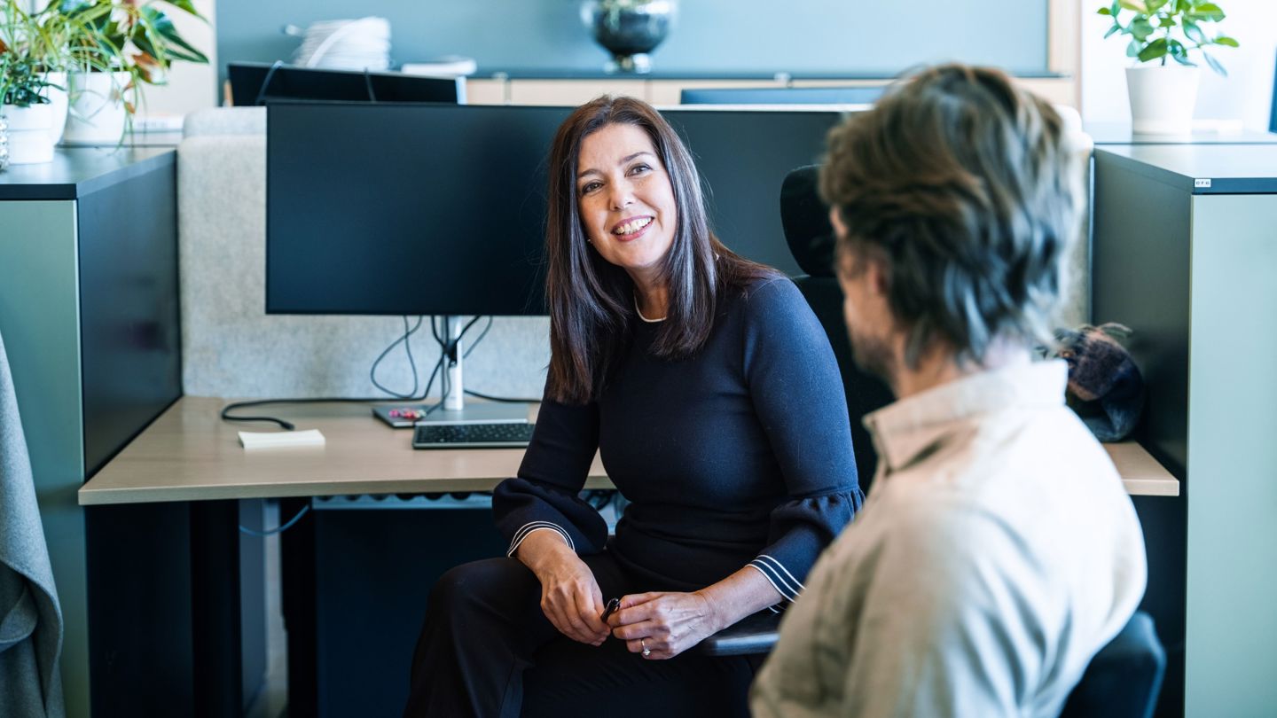 Bildet viser en kvinne som sitter i kontorlandskap.