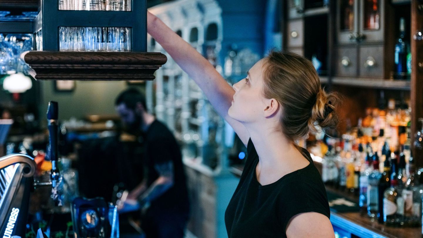 Bildet viser en kvinnelig servitør i en bar.